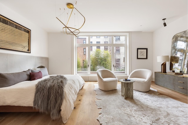 bedroom with a chandelier and light wood-style flooring