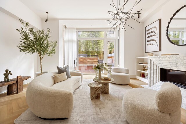 sitting room featuring a brick fireplace and a notable chandelier