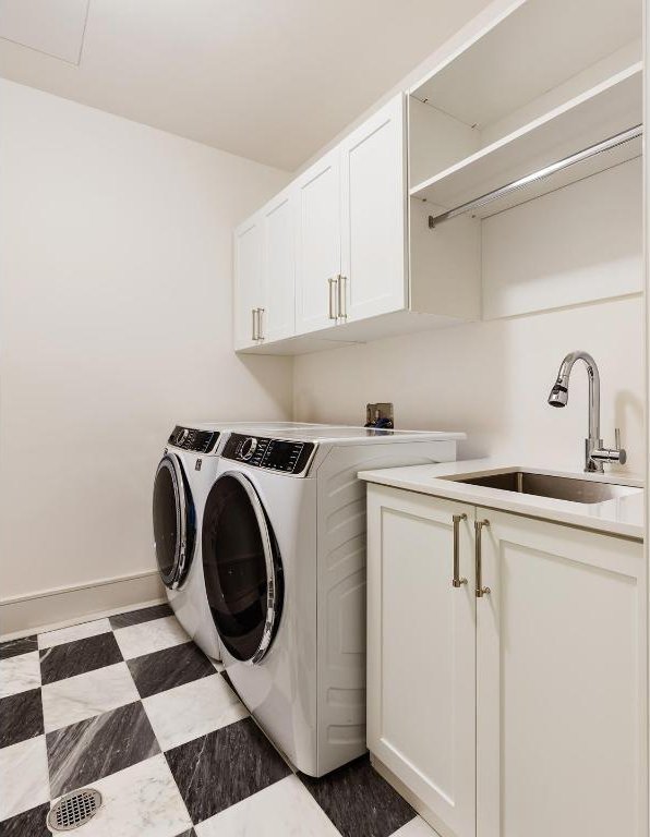 washroom featuring washer and dryer, sink, and cabinets