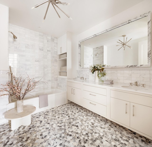 full bathroom featuring double vanity, tile walls, a tile shower, and a sink