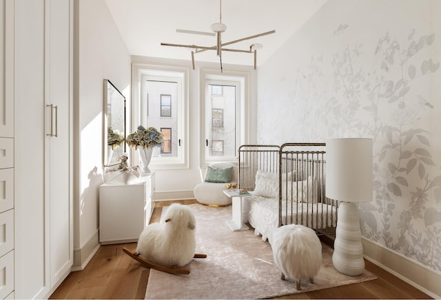 bedroom with wallpapered walls, baseboards, and light wood finished floors