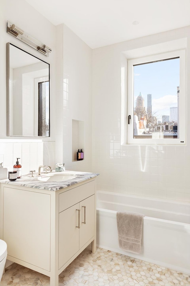 bathroom featuring vanity, toilet, and a bath