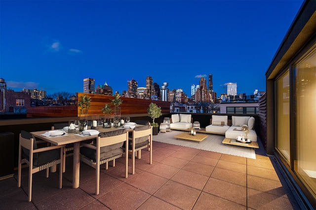 view of patio featuring outdoor dining space, a view of city lights, and an outdoor living space