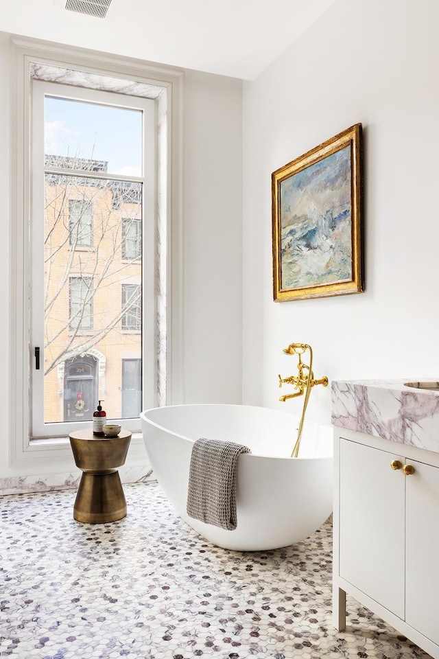 bathroom with a soaking tub and visible vents