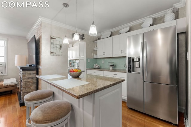 kitchen featuring decorative backsplash, pendant lighting, white cabinets, and stainless steel fridge with ice dispenser