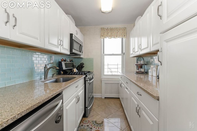 kitchen featuring appliances with stainless steel finishes, sink, and white cabinetry