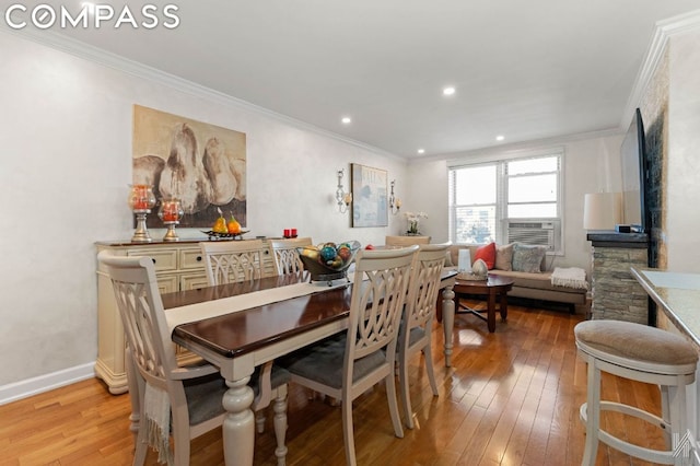 dining area featuring cooling unit, ornamental molding, and light hardwood / wood-style floors