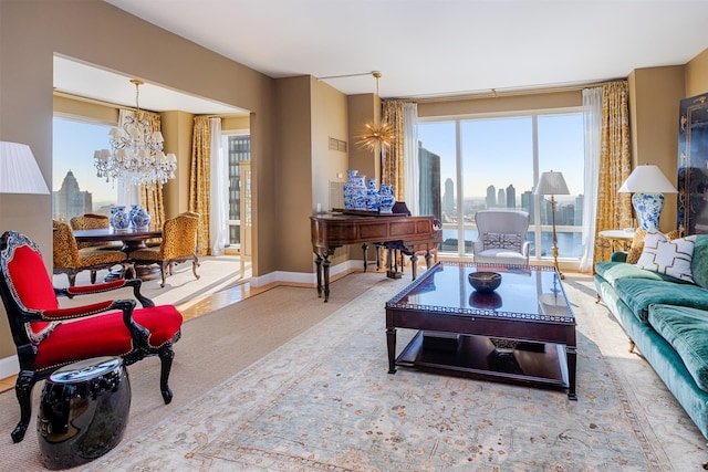 carpeted living room featuring baseboards, a notable chandelier, and a city view