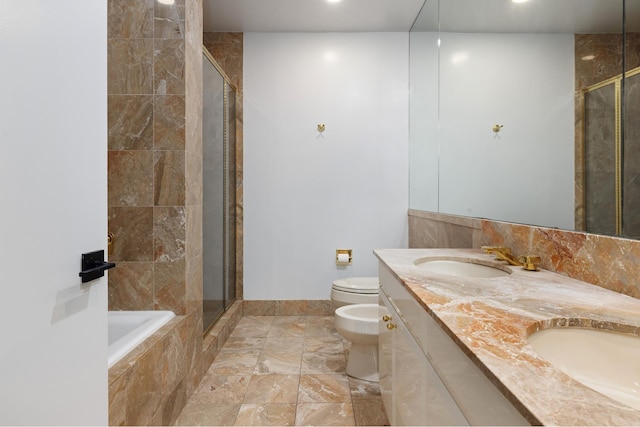 bathroom with a shower stall, toilet, a bidet, and a sink