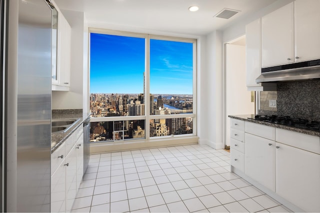 kitchen with visible vents, stainless steel appliances, under cabinet range hood, white cabinetry, and tasteful backsplash