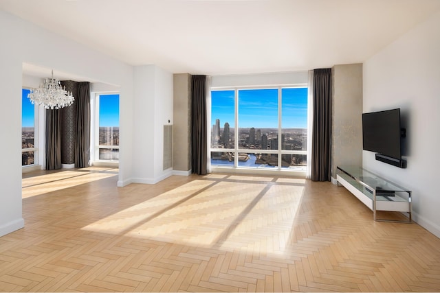 unfurnished living room with a notable chandelier and baseboards