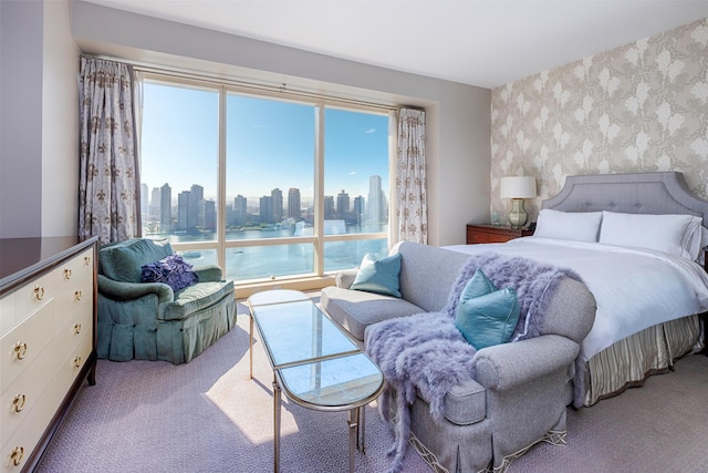 carpeted bedroom with a view of city and wallpapered walls