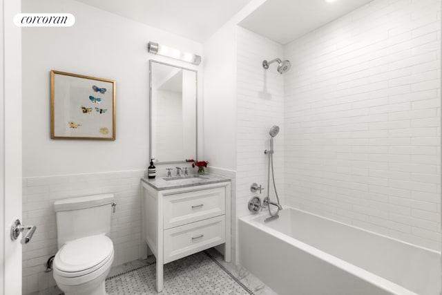 full bathroom featuring tile walls, vanity, toilet, and tiled shower / bath