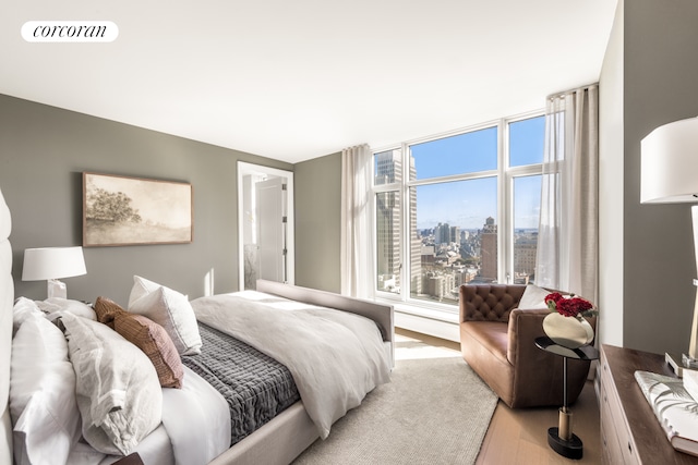 bedroom featuring visible vents, a city view, and light wood-style floors