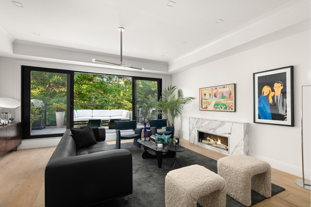 living room featuring wood finished floors, a high end fireplace, and baseboards