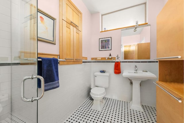 bathroom featuring tile patterned flooring, sink, tile walls, and toilet