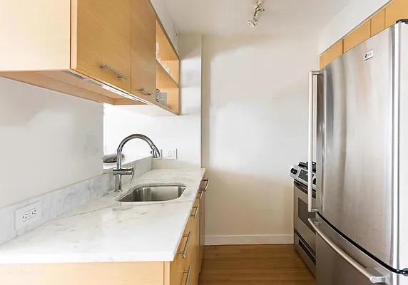 kitchen with appliances with stainless steel finishes, sink, and light hardwood / wood-style floors