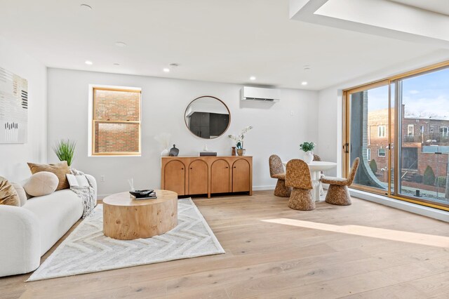 living room featuring a wall unit AC and light hardwood / wood-style floors