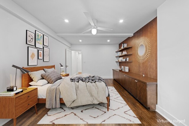 bedroom featuring ceiling fan, wooden walls, and dark hardwood / wood-style flooring