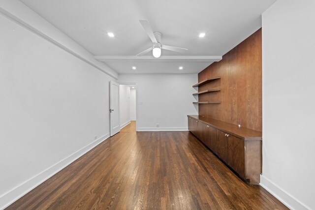 bedroom with wooden walls, ceiling fan, beam ceiling, and dark hardwood / wood-style flooring