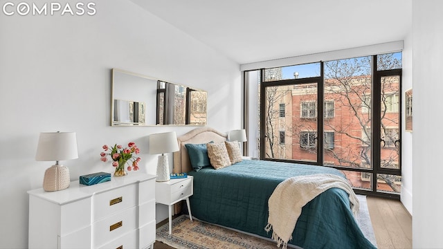 bedroom featuring floor to ceiling windows and light wood-type flooring