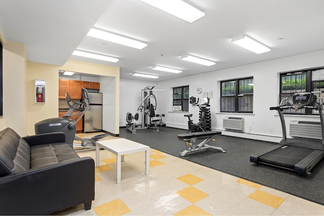 gym featuring baseboards and an AC wall unit