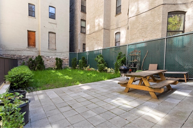 view of patio with outdoor dining space, a grill, and fence