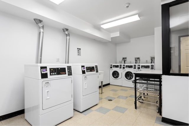 community laundry room with washer and dryer, light floors, and baseboards