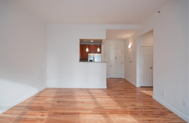 spare room with light wood finished floors and baseboards