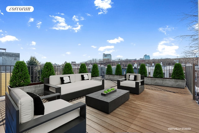 wooden deck featuring a view of city, fence, and outdoor lounge area