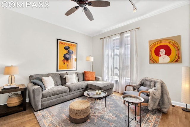 living room featuring hardwood / wood-style flooring, ornamental molding, and ceiling fan