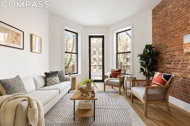 sitting room featuring hardwood / wood-style flooring and brick wall