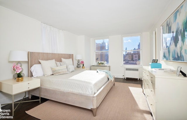 bedroom with radiator and dark hardwood / wood-style flooring