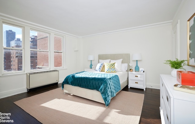 bedroom with crown molding, dark hardwood / wood-style floors, and radiator heating unit