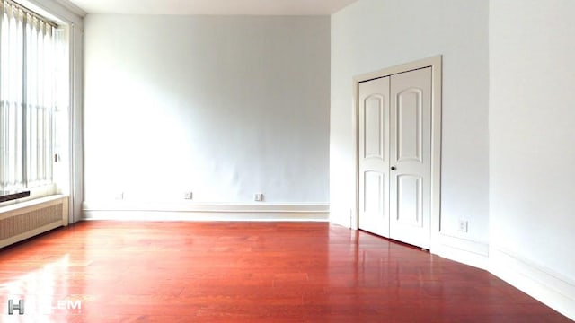 spare room with wood-type flooring and radiator heating unit