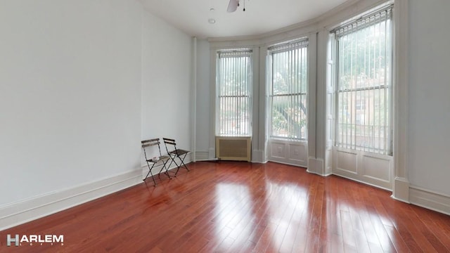 empty room featuring ceiling fan, hardwood / wood-style floors, and baseboards