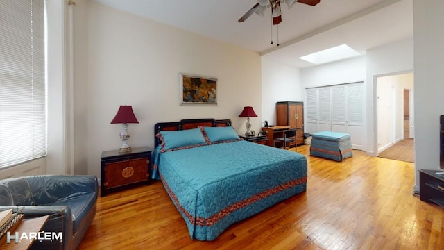 bedroom featuring a skylight, wood-type flooring, and ceiling fan