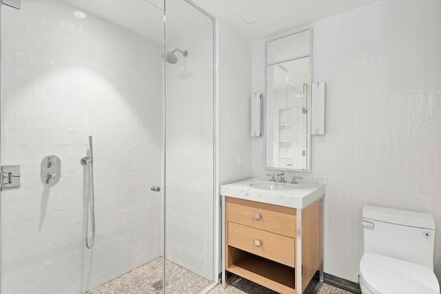 bathroom with a tile shower, vanity, and toilet