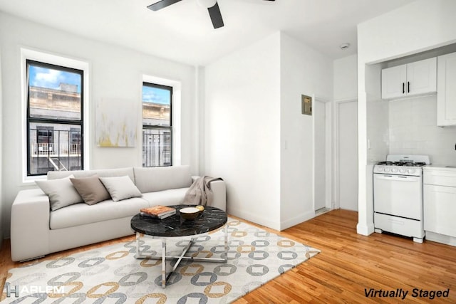 living room with ceiling fan and light wood-type flooring