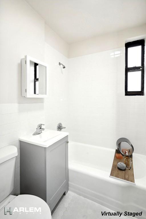 bathroom with toilet, tile patterned flooring, tile walls, and vanity