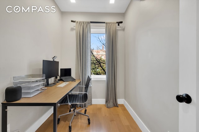 office space featuring light wood-type flooring and baseboards