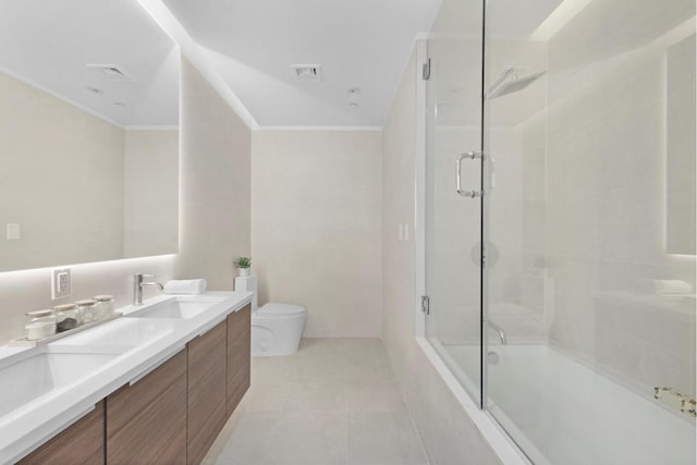 full bathroom with vanity, combined bath / shower with glass door, toilet, and ornamental molding