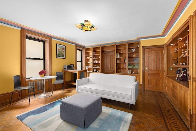 living area featuring built in shelves, dark parquet flooring, and ornamental molding