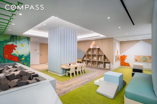 playroom with recessed lighting, a raised ceiling, and carpet flooring