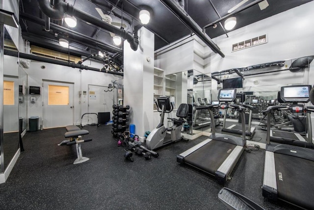 exercise room featuring a towering ceiling