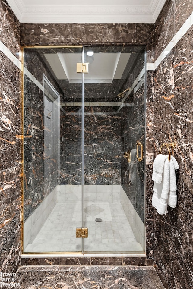 bathroom featuring ornamental molding and a marble finish shower
