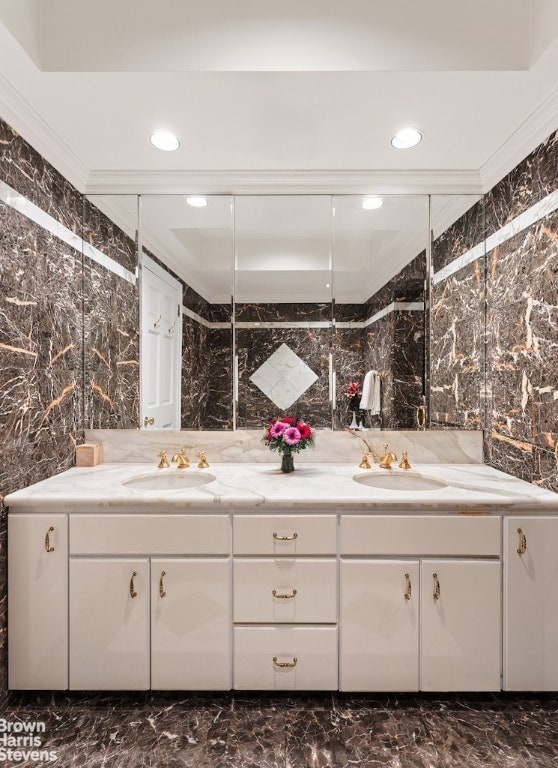 bathroom featuring vanity, crown molding, and tile walls