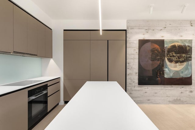 kitchen with gray cabinetry, light hardwood / wood-style flooring, and black appliances