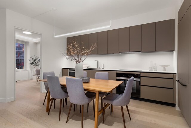 dining area featuring sink and light hardwood / wood-style floors