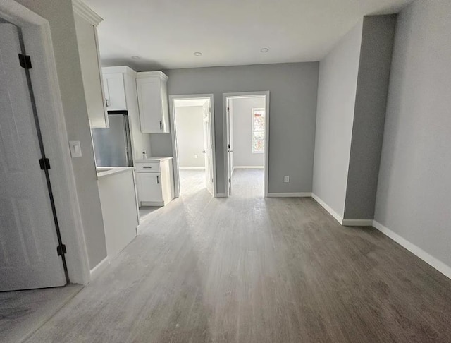 unfurnished living room with baseboards and light wood-style flooring